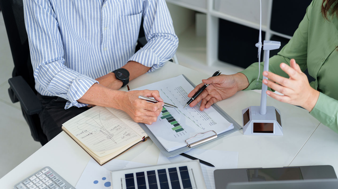 Bureau de courtier en énergie moderne avec documents contractuels, calculatrice et écran d'ordinateur affichant un comparatif de fournisseurs d'électricité français